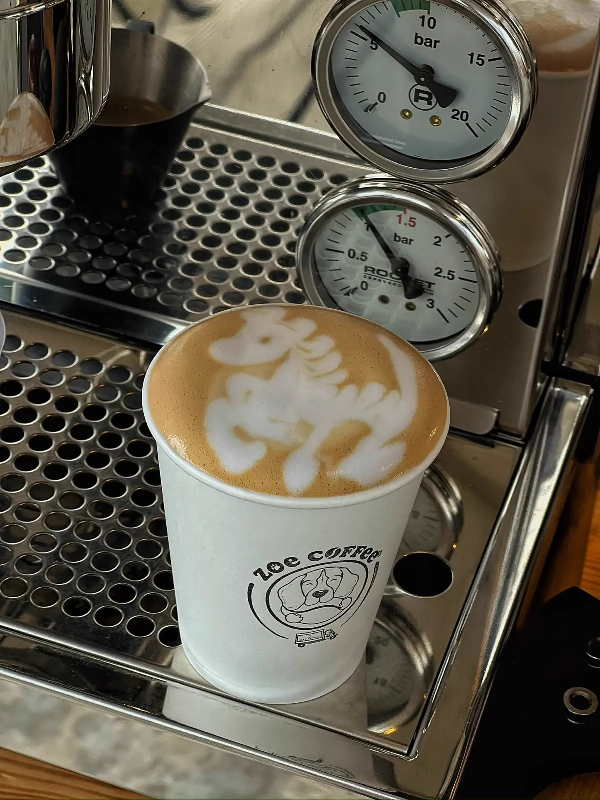Cappuccino proaspăt lângă aparatul de espresso Zoe Coffee