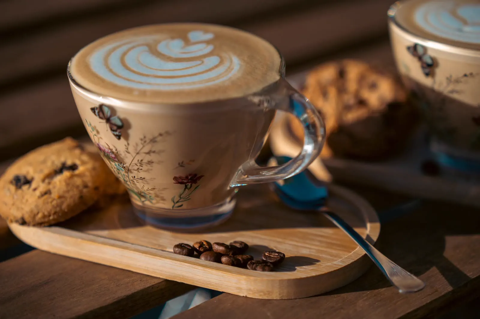 Cappuccino cu latte art într-o ceașcă de sticlă