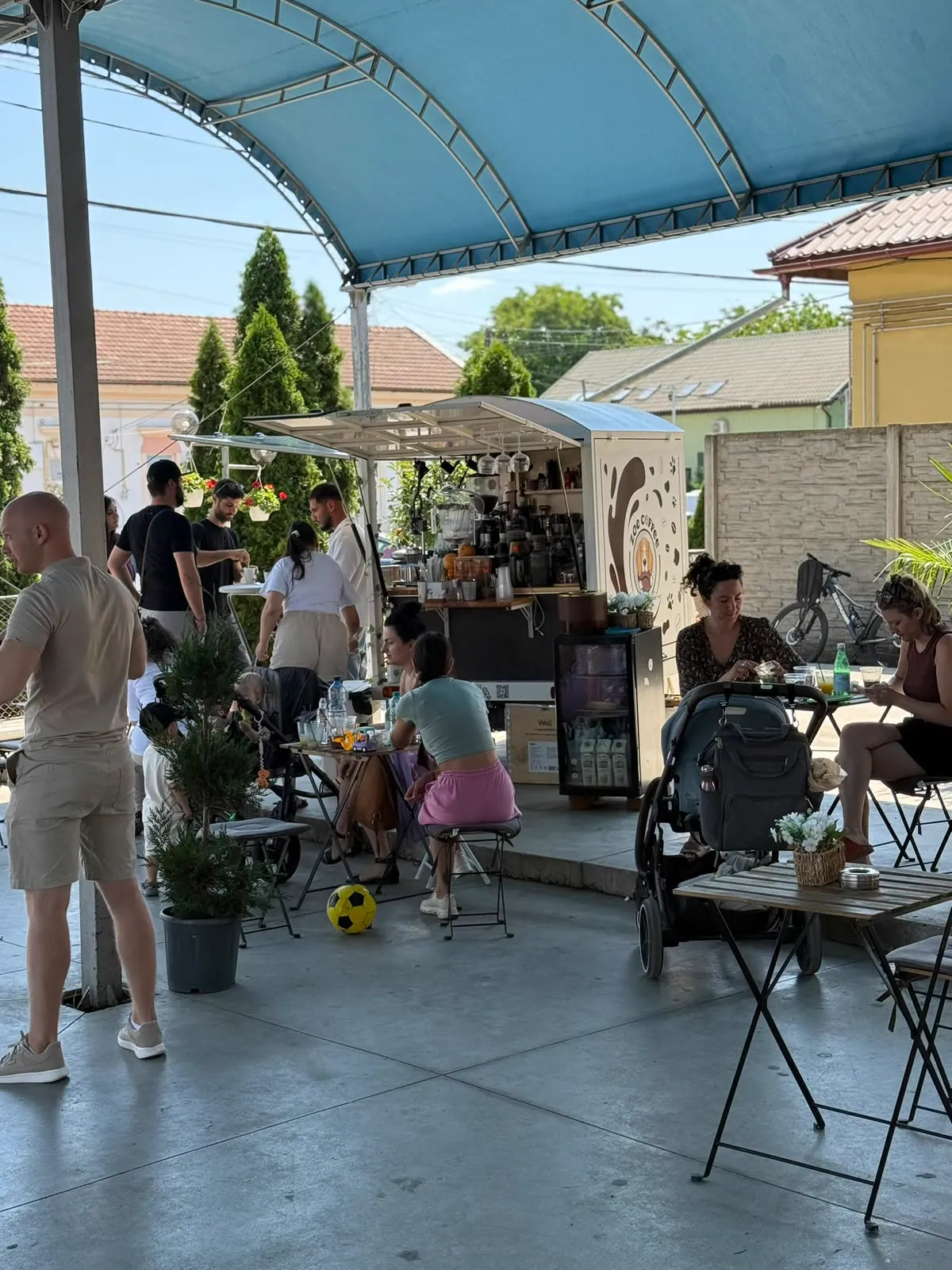 Oameni la mese, la cafea, lângă truck-ul Zoe Coffee